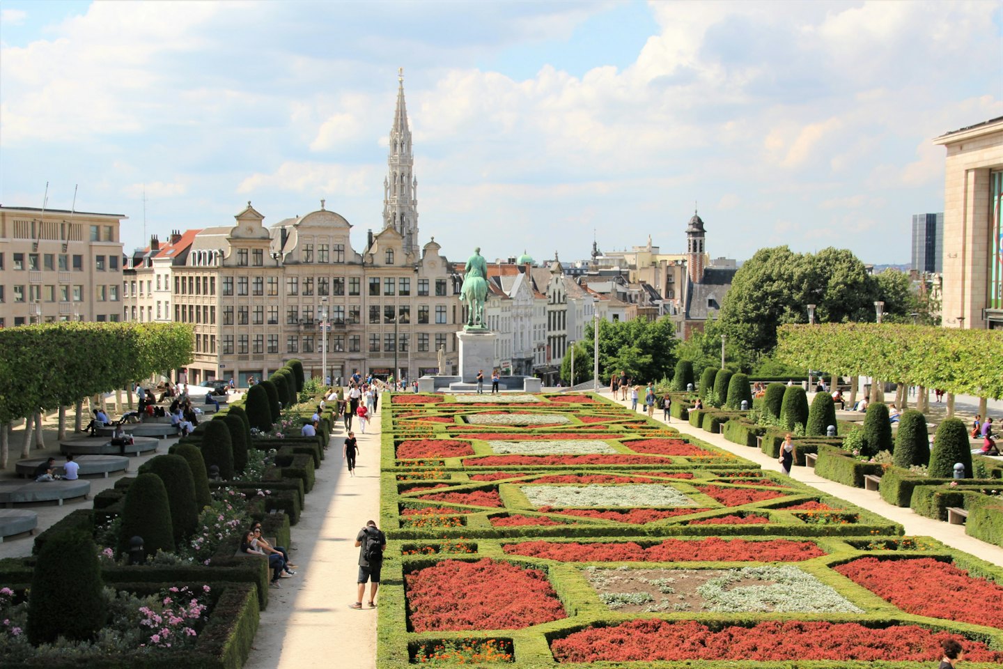 Menschen spazieren durch einen öffentlichen Park in der Nähe historischer Gebäude.