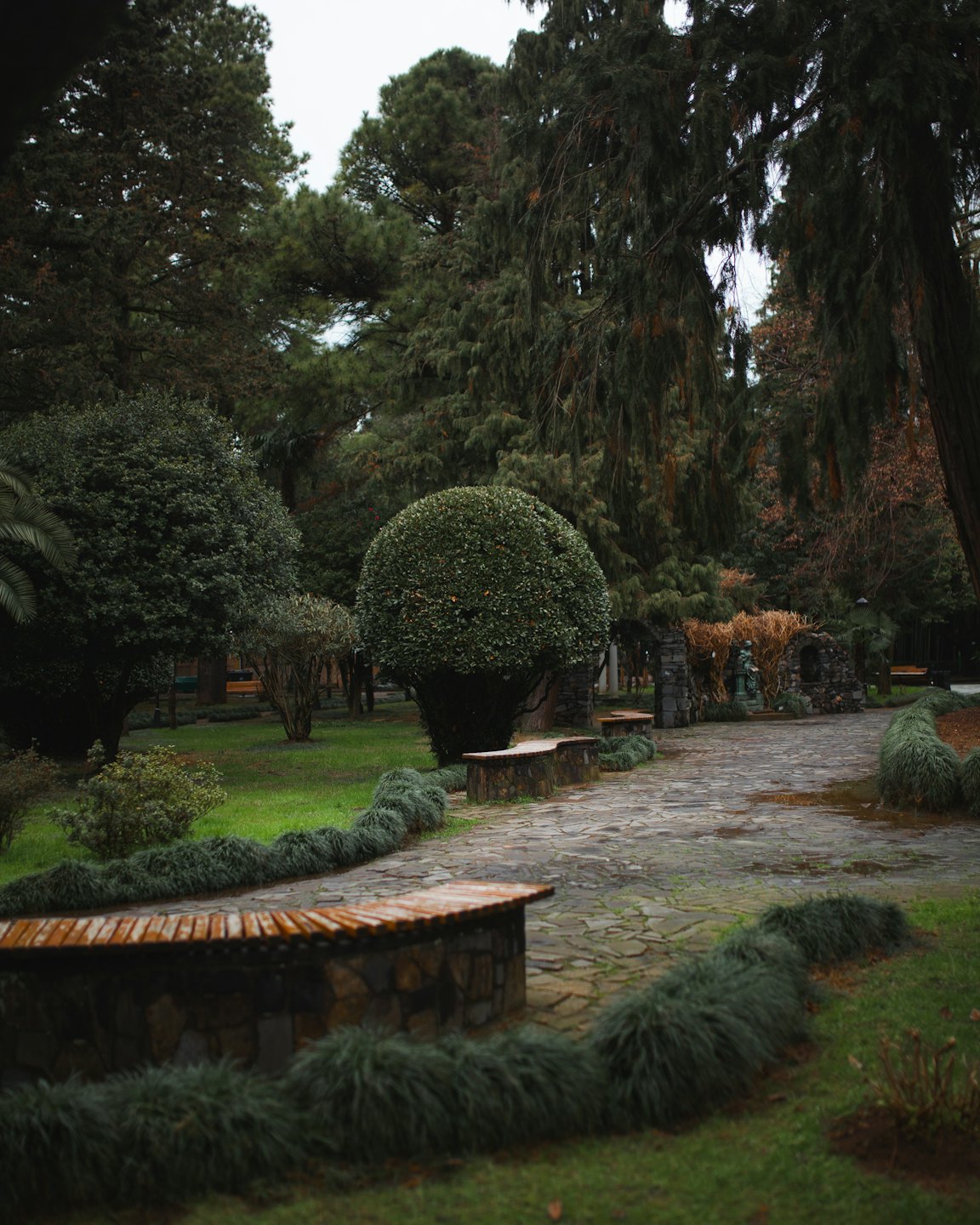 Ein gewundener Steinpfad führt durch einen üppigen grünen Garten.