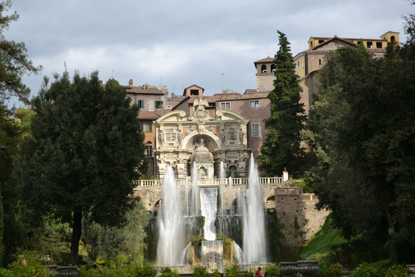 Prächtiger Barockbrunnen mit Wasserstrahlen vor einem Schloss.